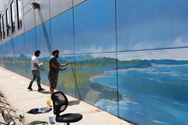 Malcolm Dickson with artist Daniel Hend installing one of the murals in Elringtons Lane.