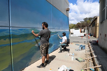 Malcolm Dickson with artist Daniel Hend installing one of the murals in Elringtons Lane.