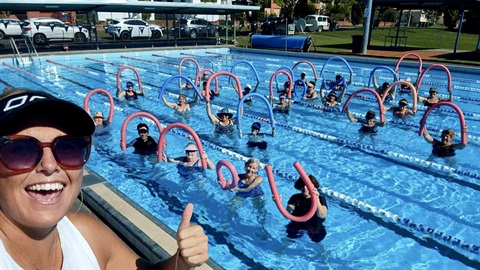 people doing thumbs up in pool