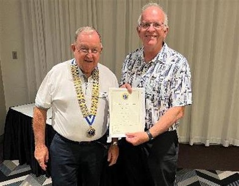 two men with one man holding a certificate