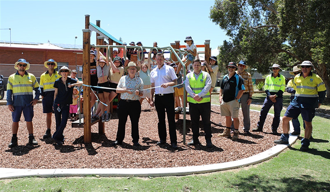 people cutting a ribbon to open a playground