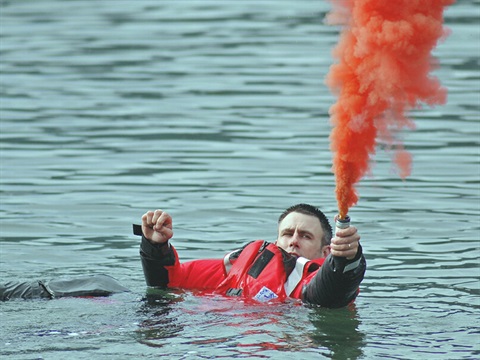 A person setting a marine flare off