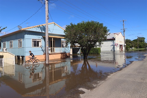 Boy rides bike through Smithtown flood water