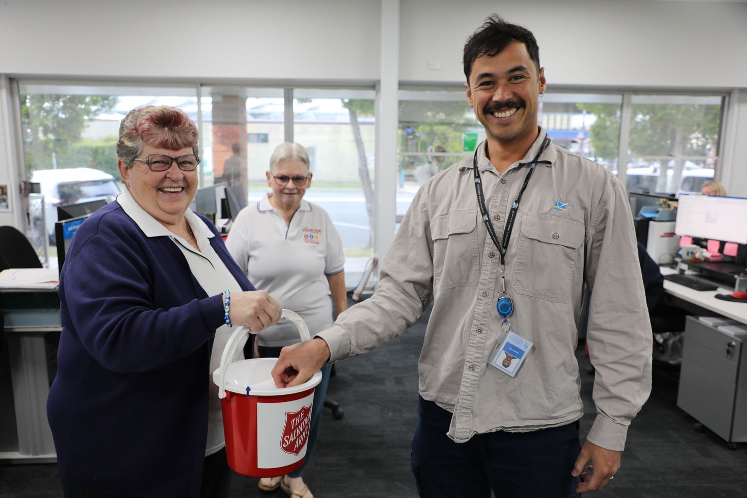 a man smiling donating money to a charity